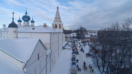 Snowy street with a large white building and a tall tower