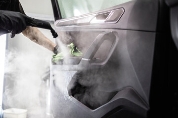 Close up view of steam cleaner machine cleaning car interior.
