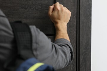 Man knocking on door to his friends apartment, closeup