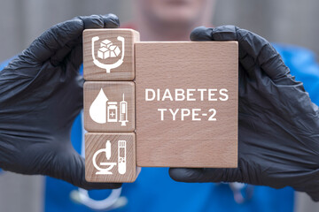 Doctor holding wooden blocks with icons sees inscription: DIABETES TYPE-2. Diabetes mellitus....