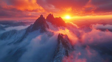 Fototapeta premium Aerial mountain scene of a dramatic ridgeline with jagged peaks and a sunrise illuminating the landscape