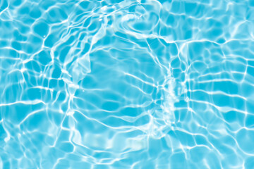 Bluewater waves on the surface ripples blurred. Defocus blurred transparent blue colored clear calm water surface texture with splash and bubbles. Water waves with shining pattern texture background.