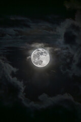 Fototapeta premium Hermosa luna llena, rodeada de nubes durante una noche obscura