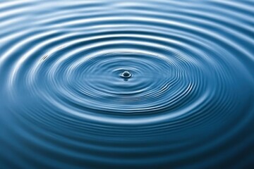 Fototapeta premium Water Drop Creating Concentric Ripples On Still Blue Water