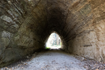 岩がむき出しの暗い雰囲気のトンネル,