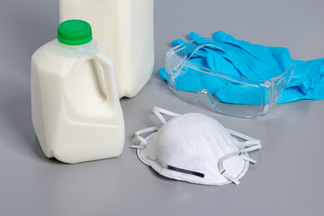 Dairy milk and personal protection equipment, PPE. H5N1 avian bird flu, farm worker safety and biosecurity protocols concept.