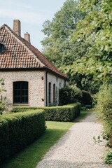 A serene pathway meanders gracefully through a vibrant, lush garden, ultimately arriving at a delightful brick house nestled in the countryside on a bright, sunny day