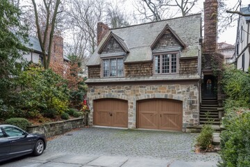 A delightful stone house featuring a rustic wooden garage nestled in a tranquil neighborhood, where trees elegantly change color in late autumn