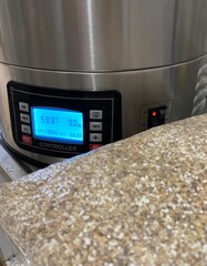 Brewing pot being set up with ground pilsner malt on the side to start the craft beer production process, brewing. Made at home with a manual process, enhancing different flavors and notes.