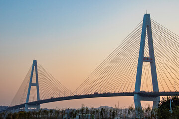 The sunset and view of Shantou Queshi Bridge at Xidi Park Shantou China is a breathtaking sight. As the sun dips below the horizon, the sky transforms into a palette of warm hues. 