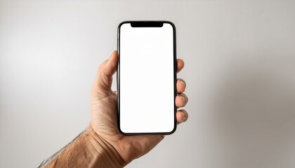 A man's hand holds a smartphone with a blank screen.