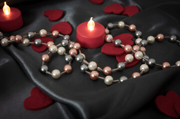 Red hearts and candles on a dark satin fabric background love you intimacy sexual Valentine day