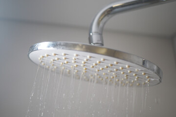A Modern Showerhead Designed for Optimal Water Flow in a Stylish Minimalist Bathroom Setting
