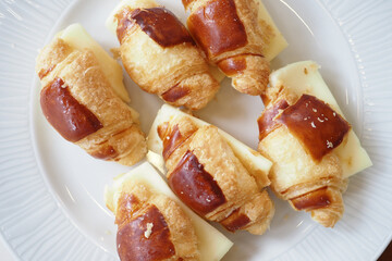 Delicious and Flaky Croissant Bites Filled with Cheese on a White Plate