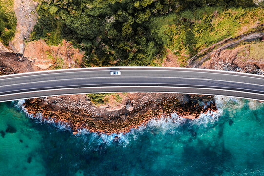 Aerial drone view of car driving on a coastal highway, Sydney, Australia
