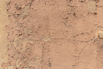 Earthy orange brown and yellow toned cracked grunge wall background texture for textured stone backdrop for ad space or copy space