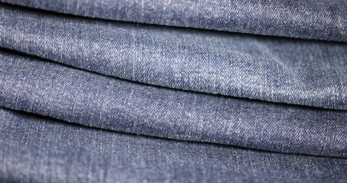 new blue denim fabric for the production of clothing and other items, the details of a piece of sturdy denim fabric, folded fabric group