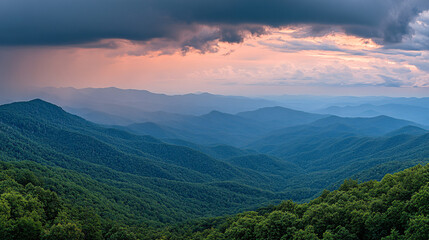 Obraz premium A panoramic view of lush, rolling mountains under a dramatic sky, showcasing layers of greenery and a hint of sunset hues.