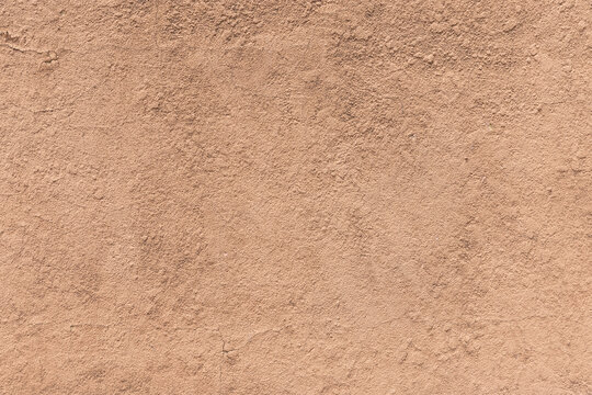 Earthy orange brown and yellow toned cracked grunge wall background texture for textured stone backdrop for ad space or copy space