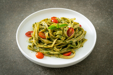 fettuccine spaghetti pasta with pesto sauce and tomatoes