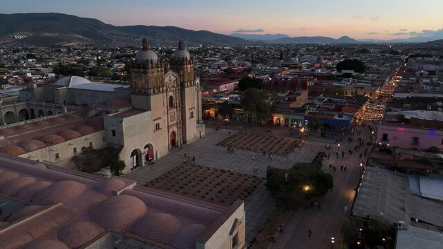 dusk flying past Templo de Santo Domingo towards view of Oaxaca
