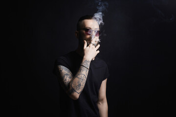 handsome bearded smoking man in sunglasses