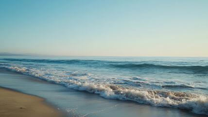 Serene Beach Scene. Gentle waves, golden sand & clear blue sky.  Peaceful & tranquil ocean shore.  Calm & relaxing coastal vista