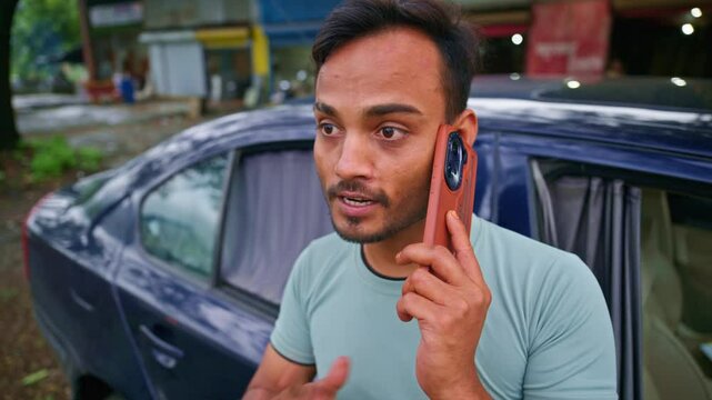 Guy makes a call standing next to the car