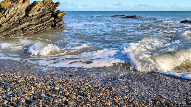 Waves splashes on rock in sea shore: Malahide and Howth beach in Dublin, Ireland Irish sea coastline. 