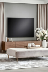 Modern living room interior design, featuring a large flat-screen TV, beige furniture, and stylish decor.  Ideal for home decor websites or magazines
