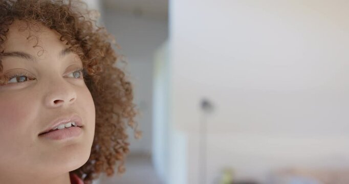 Close-up of woman with curly hair looking away, focusing on fitness goals, copy space