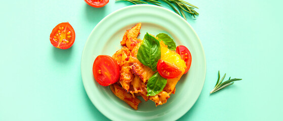 Plate of pasta with tomato sauce and cheese on turquoise background