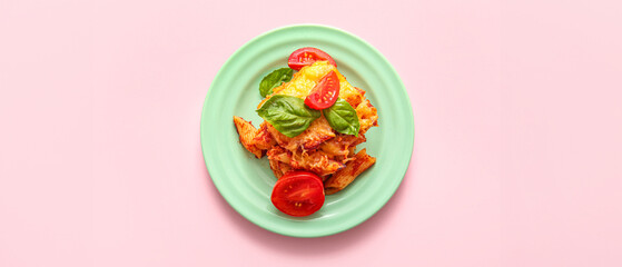 Plate of pasta with tomato sauce and cheese on pink background