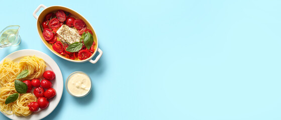 Baking dish with tasty tomatoes, feta cheese and pasta on blue background