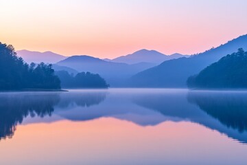 Fototapeta premium Serene lake reflecting mountains during a pastel sunrise