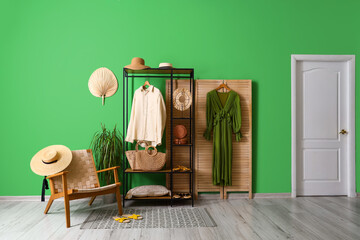 Interior of dressing room with shelving unit, clothes and armchair