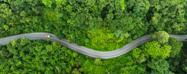 Forest road ,Top view of road in the middle of the forest curve construction up to mountain, panoramic view of Rainforest ecosystem elevated road that surrounds natural forest.