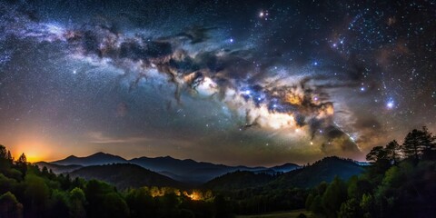 Naklejka premium Dark Alabama night sky with Milky Way rising above mountains and trees, casting a silver glow on the landscape , cosmos