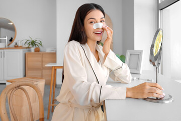 Young woman applying nose patch at home