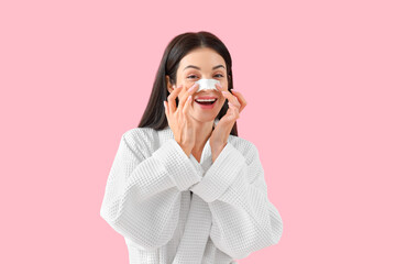 Young woman with nose patch on pink background