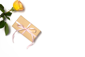 Gift box with rose on white background. Flat lay, top view. Copy space