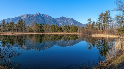 Obraz premium Serene Mountain Lake Reflection Under Clear Blue Sky in Nature