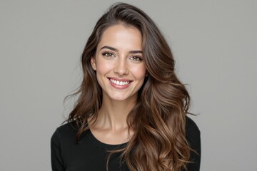 Naklejka premium Beautiful woman with long wavy brown hair wearing atop, smiling radiantly, neutral gray background, concept of confidence and positivity. Ai generative