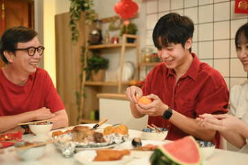 Warm asian family enjoying traditional dishes during Chinese New Year reunion dinner