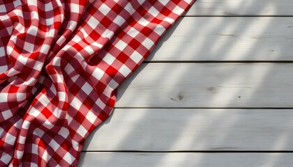 Cheerful red and white gingham fabric on a wooden table, setting the scene for a lovely spring picnic