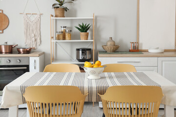 Colander with lemons on dining table in kitchen interior