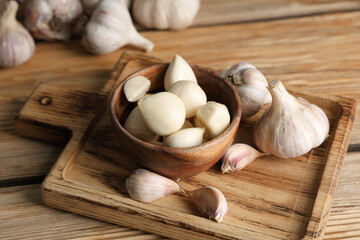Bowl with fresh garlic cloves on wooden background