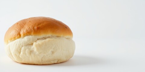 A freshly baked bun with a golden brown crust, showcasing its soft and fluffy texture, ready to be filled with delicious ingredients.