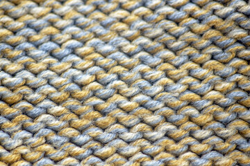 Close-up of a multi-colored sweater: a product created from yarn combining blue, white and yellow...