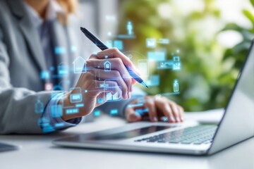 Hand holding a pen near a laptop with virtual icons overlayed, on blurred background.